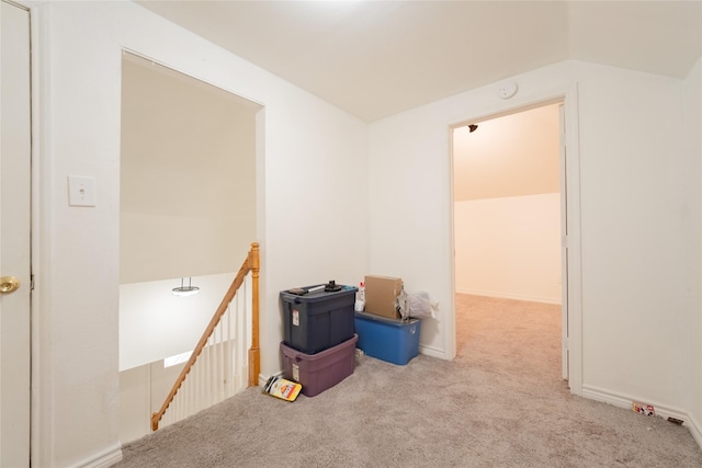 carpeted empty room with vaulted ceiling