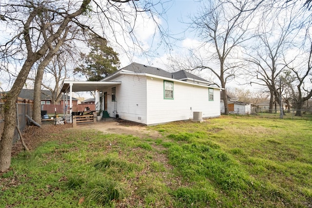 rear view of house with a yard and central air condition unit