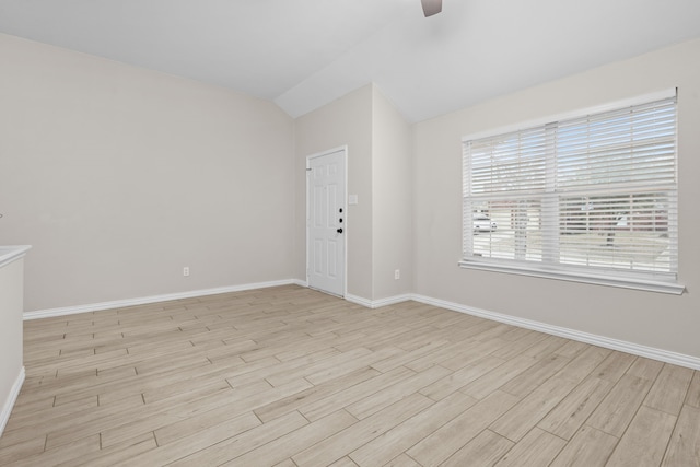 spare room with lofted ceiling, ceiling fan, and light hardwood / wood-style flooring