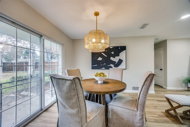 dining room featuring light hardwood / wood-style floors and a chandelier