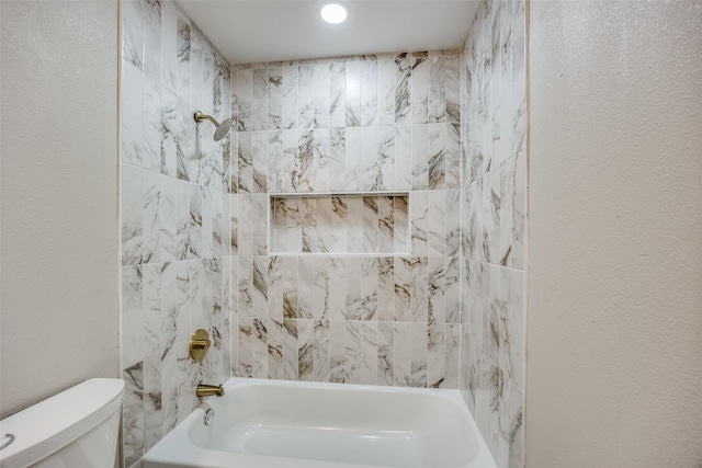 bathroom with tiled shower / bath and toilet