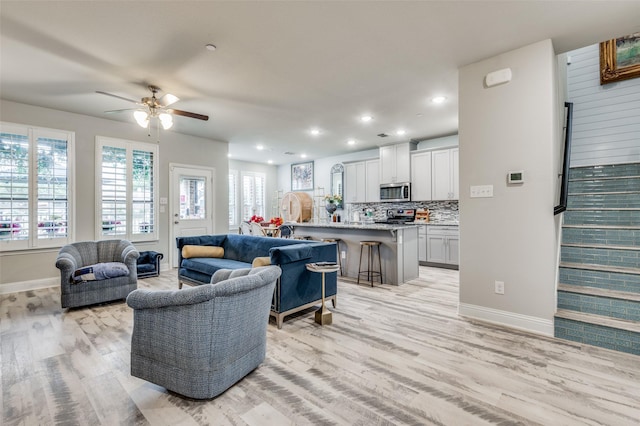 living room featuring ceiling fan and light hardwood / wood-style floors