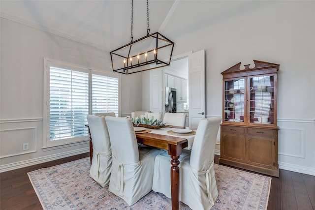 dining area featuring crown molding, dark hardwood / wood-style floors, and an inviting chandelier