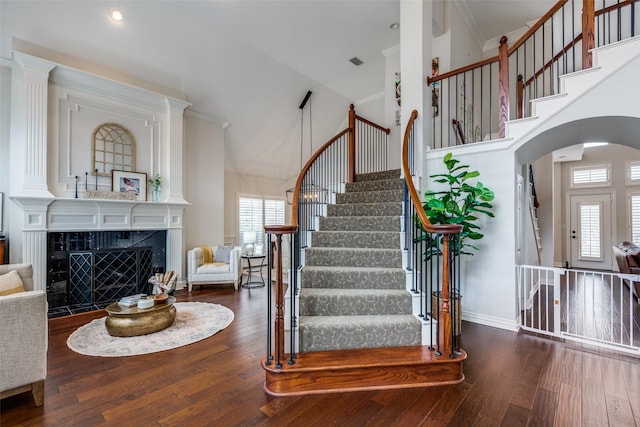 foyer entrance with a premium fireplace, dark hardwood / wood-style flooring, and a high ceiling