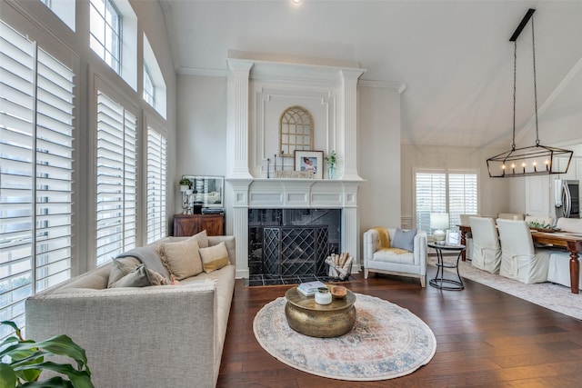 living room with a notable chandelier, crown molding, dark wood-type flooring, and a high end fireplace