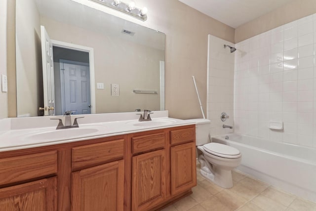 full bathroom with vanity, tiled shower / bath combo, tile patterned floors, and toilet