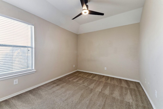 carpeted empty room featuring vaulted ceiling and ceiling fan