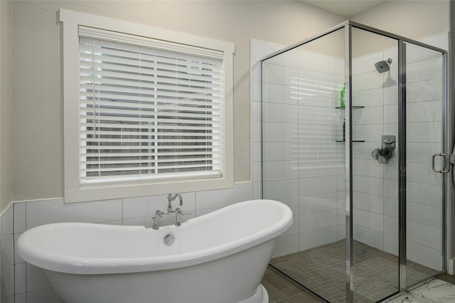 bathroom featuring separate shower and tub and tile walls