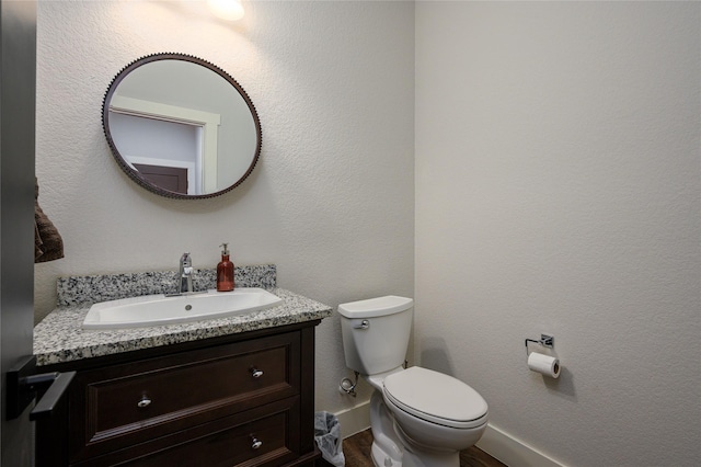 bathroom featuring vanity, wood-type flooring, and toilet