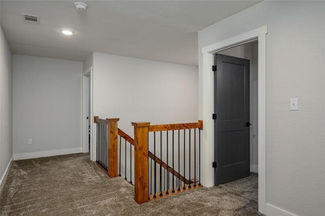 hallway featuring dark colored carpet