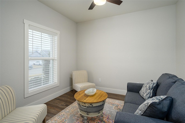 living area featuring ceiling fan and dark hardwood / wood-style flooring