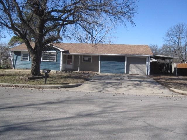 ranch-style home featuring a garage and a carport