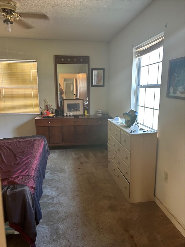 carpeted bedroom with ceiling fan and a textured ceiling