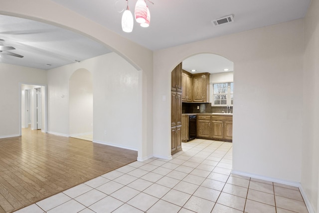 tiled spare room featuring sink and ceiling fan