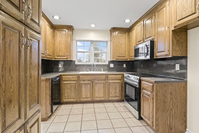 kitchen with stainless steel appliances, sink, light tile patterned floors, and decorative backsplash