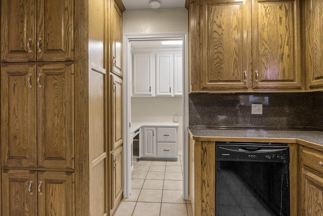 kitchen featuring light tile patterned flooring, black dishwasher, and decorative backsplash