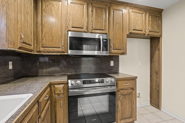 kitchen featuring tasteful backsplash, light tile patterned floors, sink, and appliances with stainless steel finishes