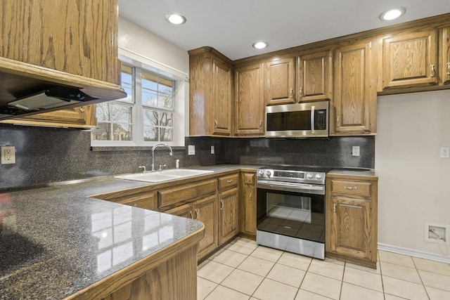 kitchen featuring tasteful backsplash, appliances with stainless steel finishes, sink, and light tile patterned floors