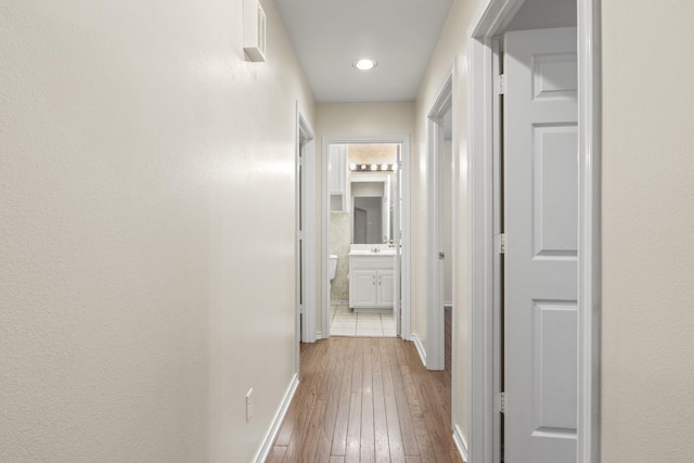 hall featuring sink and light wood-type flooring