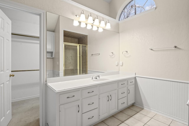 bathroom featuring vanity, a shower with shower door, and tile patterned flooring