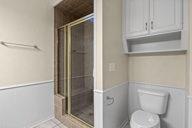 bathroom featuring tile patterned floors, toilet, and walk in shower