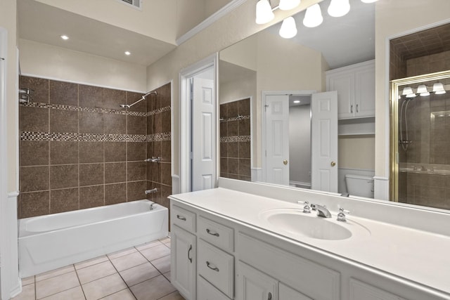 full bathroom featuring tile patterned flooring, vanity, tiled shower / bath, and toilet