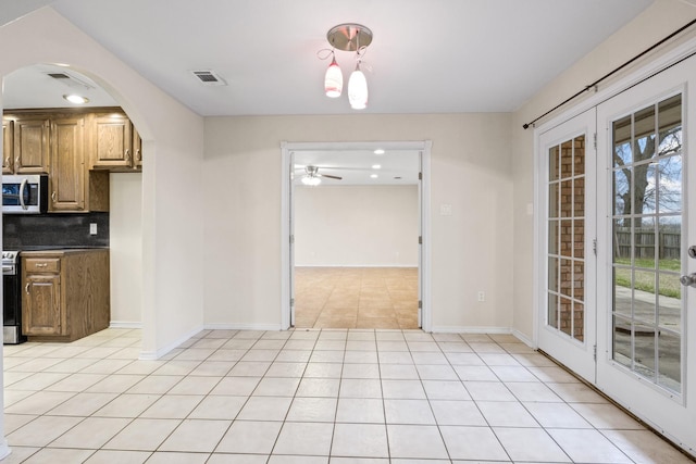 unfurnished dining area featuring light tile patterned floors and ceiling fan