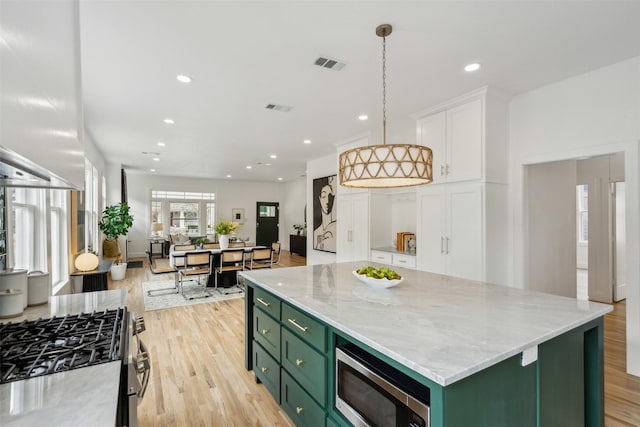 kitchen featuring a kitchen island, white cabinetry, appliances with stainless steel finishes, and green cabinetry