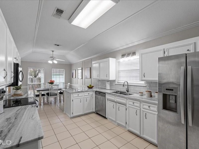 kitchen featuring white cabinetry, sink, stainless steel appliances, and kitchen peninsula