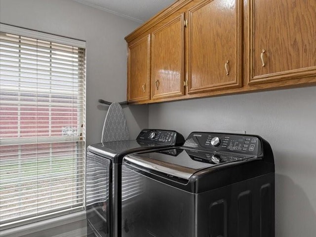 laundry room with cabinets, washing machine and dryer, and a wealth of natural light