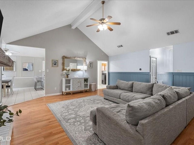 living room with beam ceiling, high vaulted ceiling, hardwood / wood-style flooring, and ceiling fan