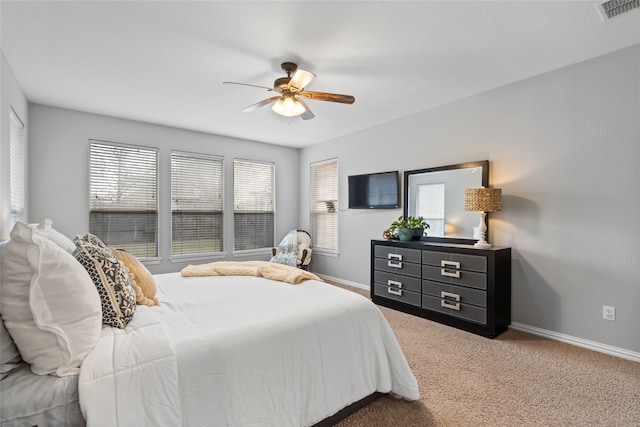 carpeted bedroom featuring multiple windows and ceiling fan