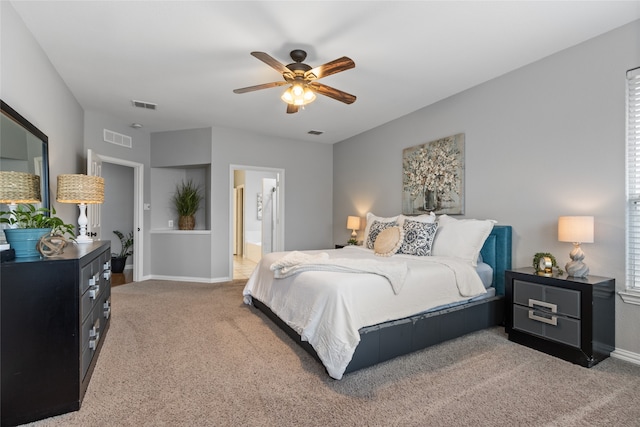 carpeted bedroom featuring ceiling fan and ensuite bath