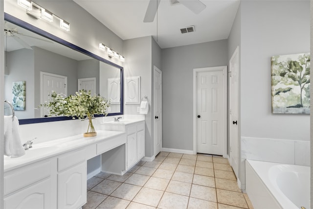 bathroom featuring ceiling fan, vanity, tiled bath, and tile patterned floors