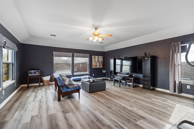 living room featuring ceiling fan, vaulted ceiling, and light hardwood / wood-style flooring