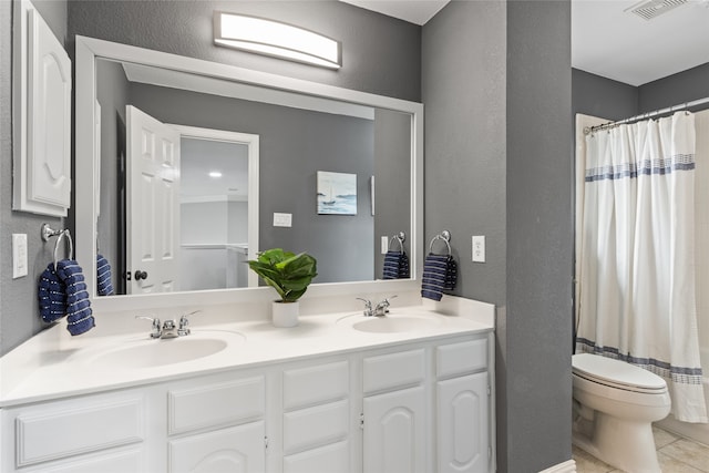 bathroom featuring walk in shower, vanity, toilet, and tile patterned flooring