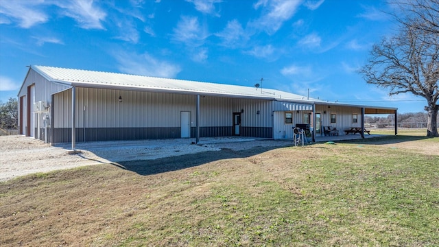 back of property with an outbuilding and a lawn