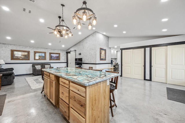 kitchen with a center island, vaulted ceiling, hanging light fixtures, a kitchen breakfast bar, and a barn door