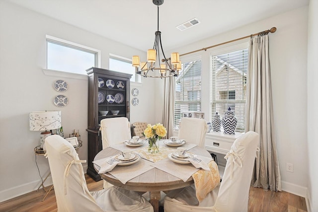 dining area featuring hardwood / wood-style floors and a notable chandelier