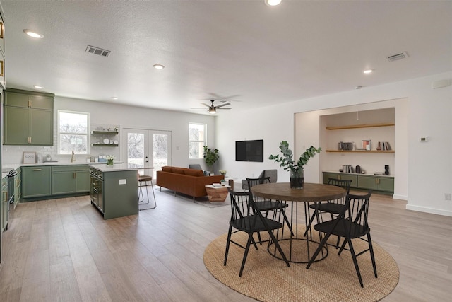 dining area featuring a healthy amount of sunlight, light wood-style floors, and visible vents