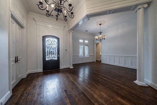 foyer entrance featuring an inviting chandelier, ornamental molding, dark wood-type flooring, and ornate columns