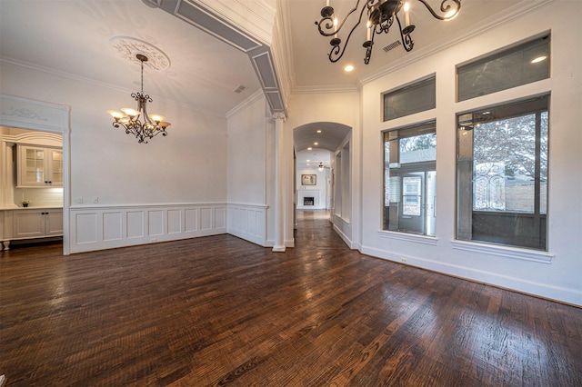 empty room with an inviting chandelier, crown molding, and dark hardwood / wood-style flooring