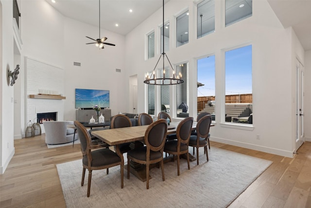 dining room with ceiling fan with notable chandelier and light hardwood / wood-style floors