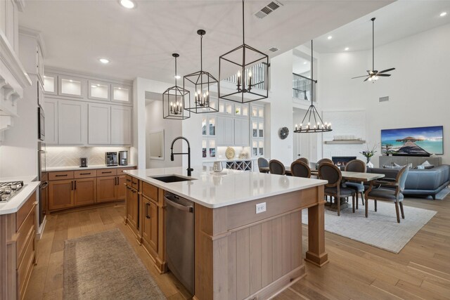 kitchen featuring a sink, visible vents, stainless steel appliances, light wood-style floors, and open floor plan