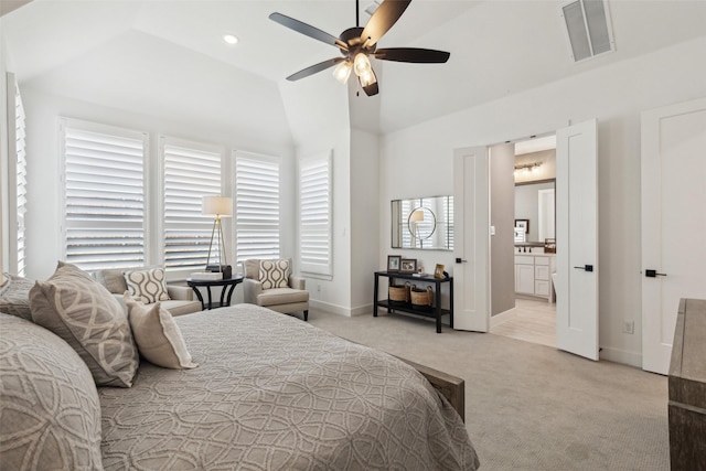 carpeted bedroom featuring lofted ceiling, connected bathroom, and ceiling fan