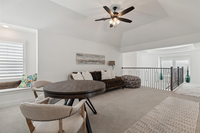 living room featuring ceiling fan, vaulted ceiling, and light carpet