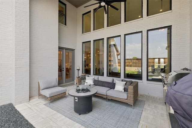 view of patio featuring grilling area, an outdoor living space with a fire pit, and ceiling fan