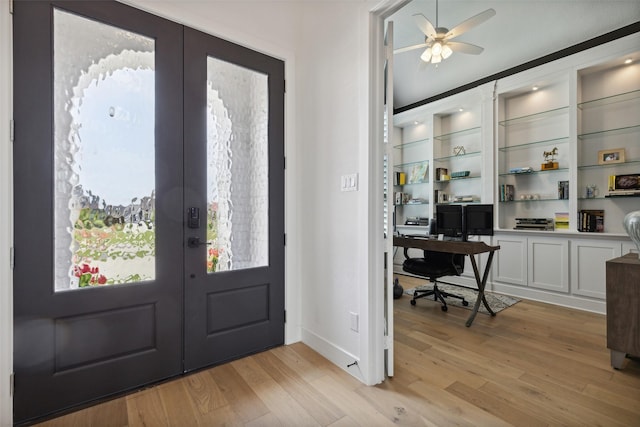 foyer entrance with french doors, ceiling fan, and light wood-type flooring