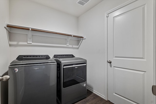 laundry area featuring dark wood-type flooring and washing machine and dryer