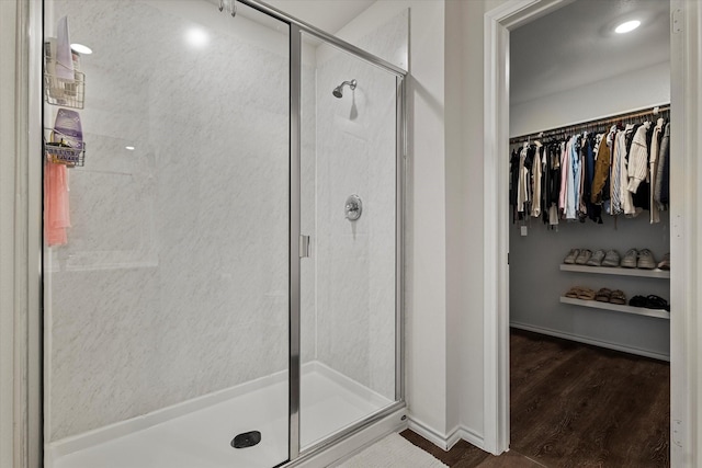 bathroom with wood-type flooring and a shower with shower door